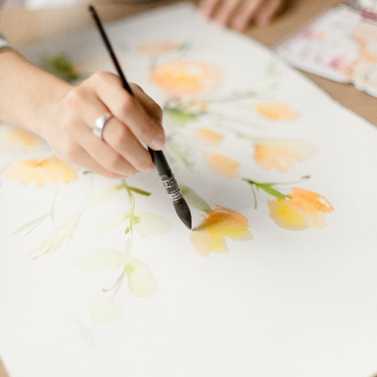 artiste qui peint des fleurs à l'aquarelle