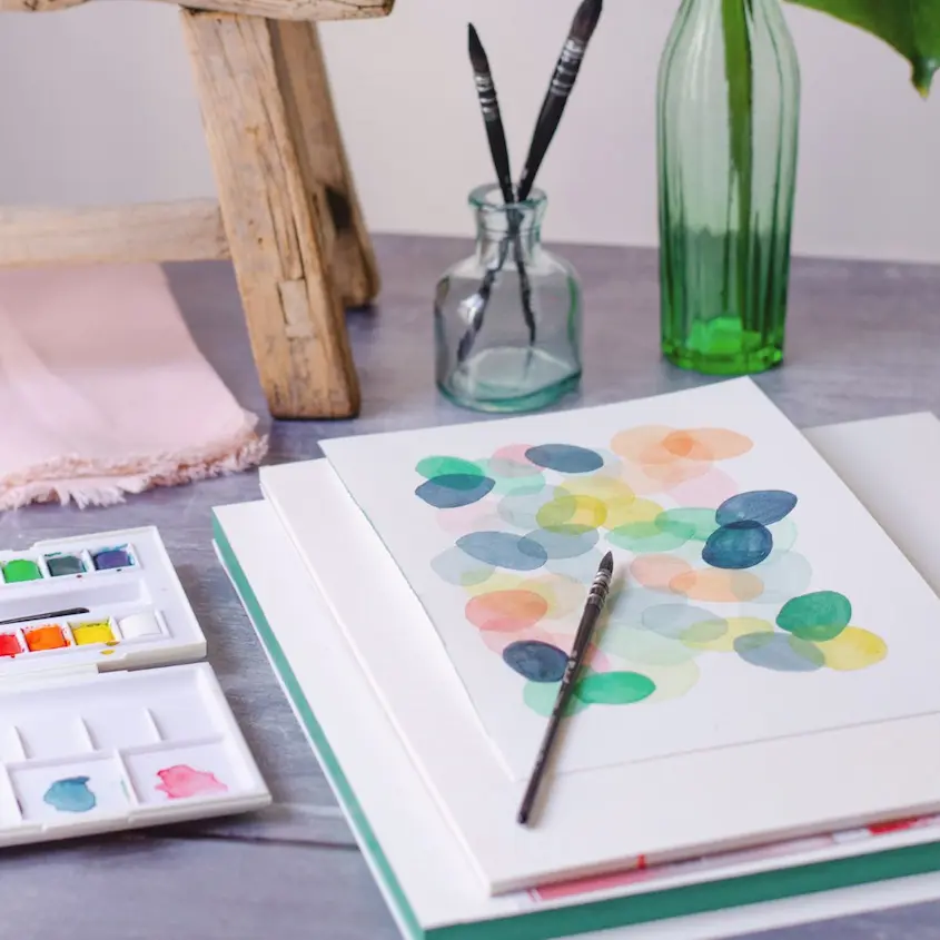 création à l'aquarelle avec pinceaux et palette de couleurs